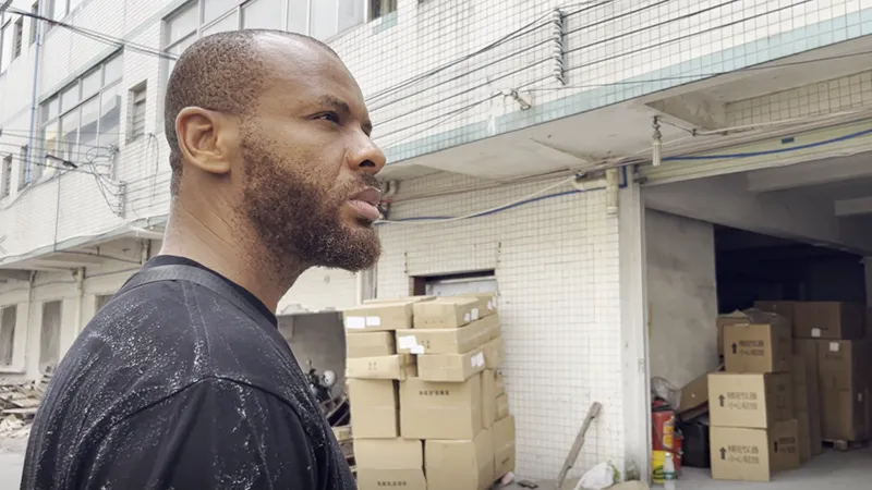 African business client overseeing cargo boxes at a Chinese logistics warehouse for B2B shipping